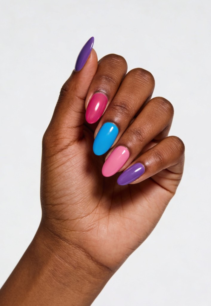Close-up of a hand with long almond-shaped nails in glossy purple, pink, and blue polish